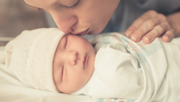 Baby sleeping, swaddled, kiss