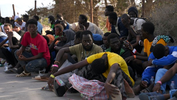 Des migrants sont assis dans le port de l'île italienne de Lampedusa, le 16 septembre 2023.