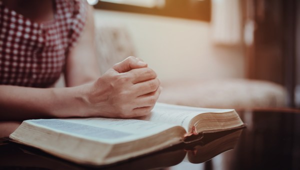 kobieta czyta Biblię siedząc na kanapie