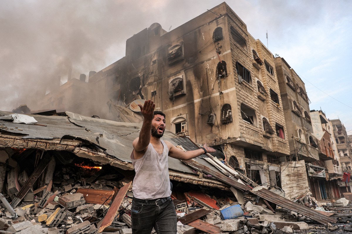 Man shouts in front of bombed Gaza building
