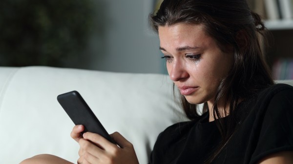 Woman watching phone tears