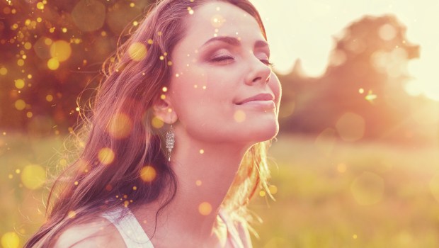 Młoda kobieta na polu w blasku zachodzącego Słońca