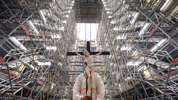 Crucifix carried in Notre Dame cathedral in Paris on April 15, 2022 marking third anniversary since the fire
