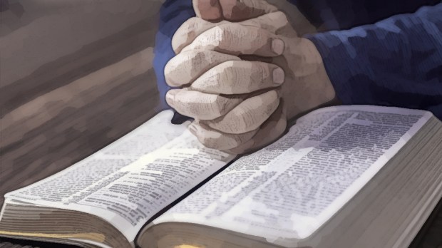 Hands folded in prayer over Bible as man reads it offscreen