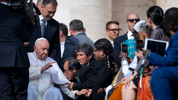 A man kisses the Pope's hand
