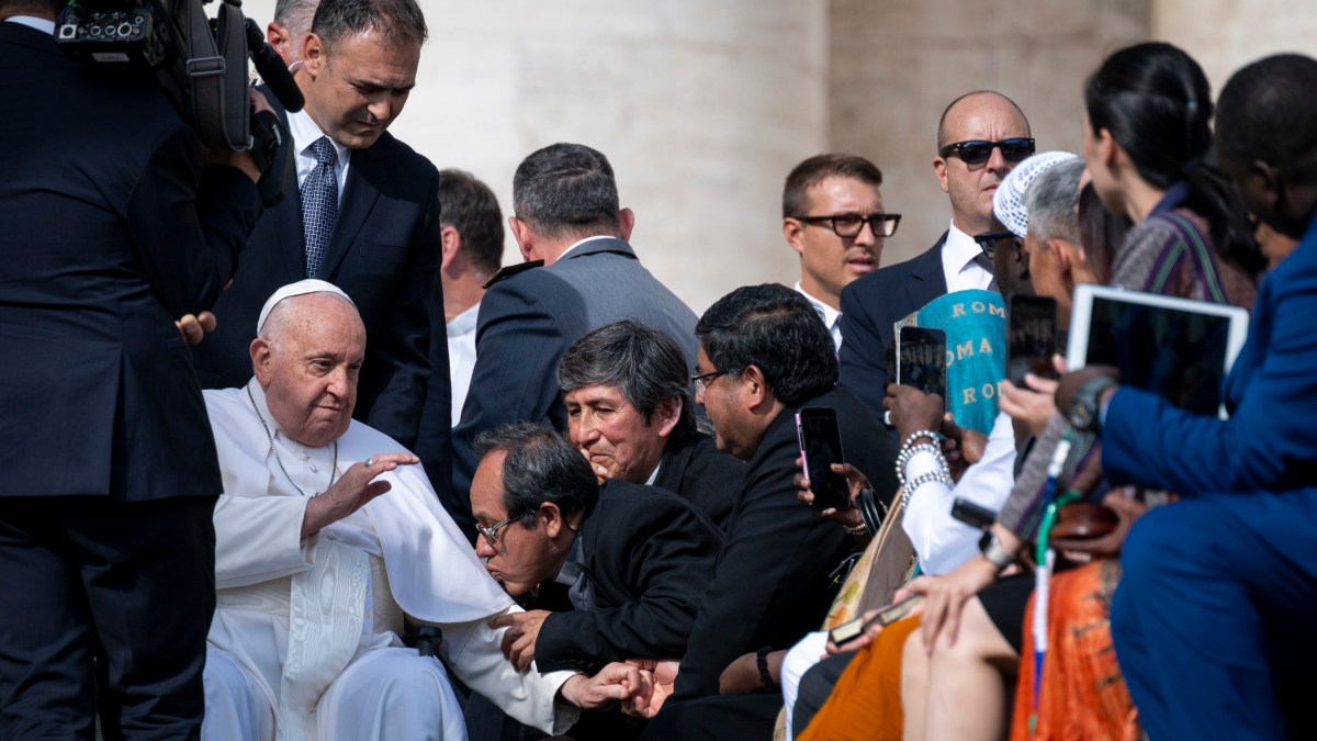A man kisses the Pope's hand