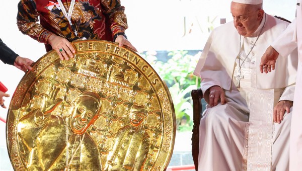 Pope Francis looks at a gift presented by Indonesia's Deputy Minister of Religious Affairs Saiful Rahmat Dasuki during an inter-religious meeting at the Istiqlal Mosque in Jakarta on September 5, 2024.