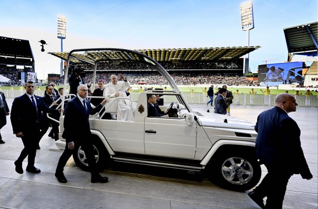 Pope Francis waves to the faithful from the popemobile as he arrives at King Badouin Stadium to hold a holy mass, in Brussels on September 29, 2024