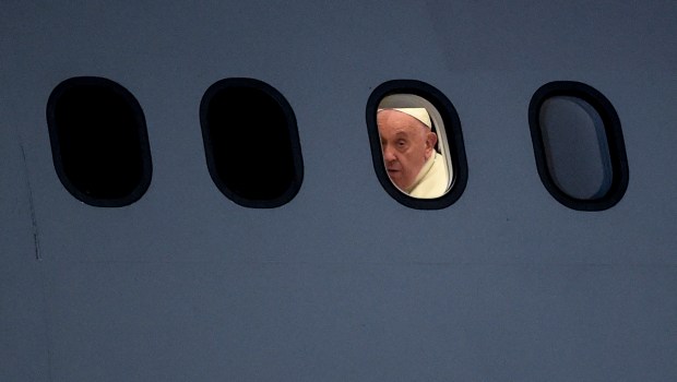Pope Francis is seen through a window of the plane upon arrival at Port Moresby International airport on September 6, 2024.