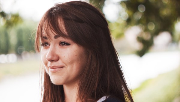 La fille pleure et sourit. Des yeux bouffants. Portrait émotionnel d'une belle brune. Dépression, tristesse, solitude