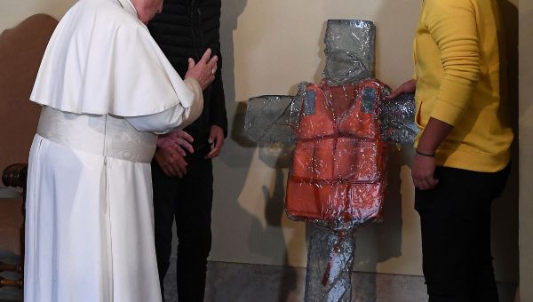 Pope Francis blesses a cross in memory of migrants and refugees during an audience with refugees who arrived from the Greek island of Lesbos, on December 19, 2019 at the Vatican.