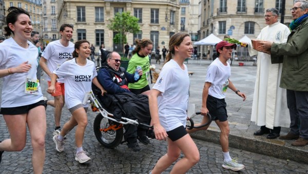 Coureurs du Paris Eglises Tour 2025 avec une joëlette.