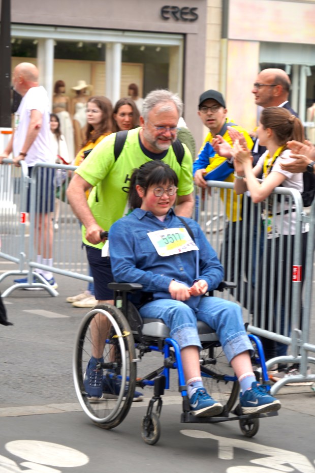 Un coureur et une jeune fille handicapée lors du Paris Eglises Tour 2025.